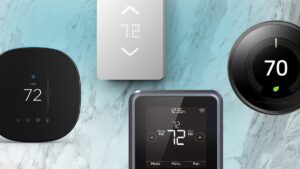 several-smart-thermostats-lined-up-against-a-blue-backdrop.