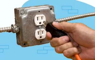 person plugging a cord in an outlet