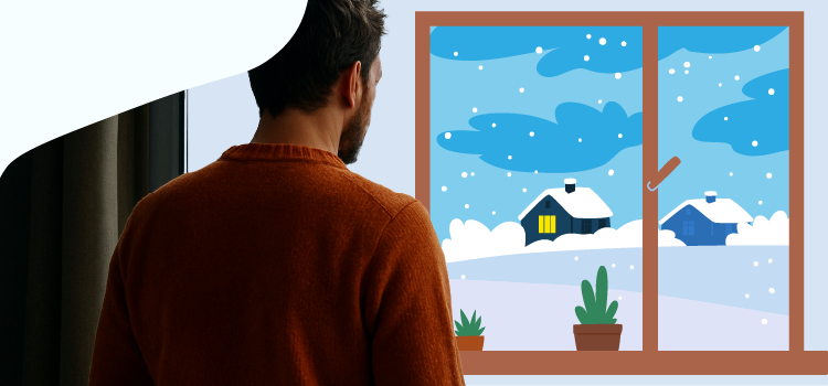 Man-looking-out-a-window-at-a-snowy-landscape