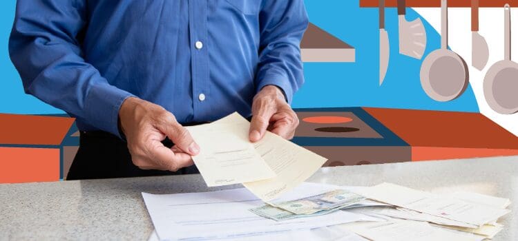 man-looking-at-his-bills-in-the-kitchen